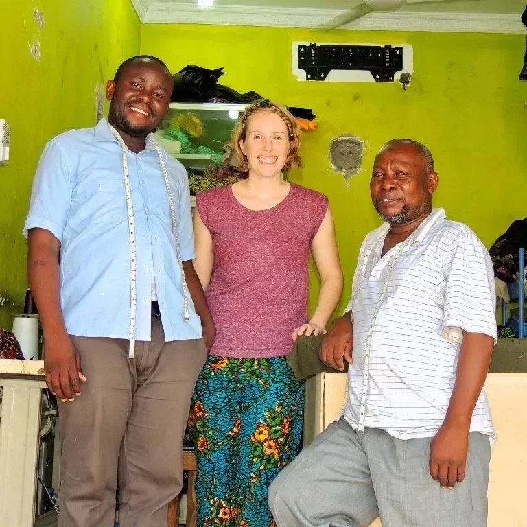 kitenge-store-founder-sian-standing-with-african-menswear-tailors-tanzania
